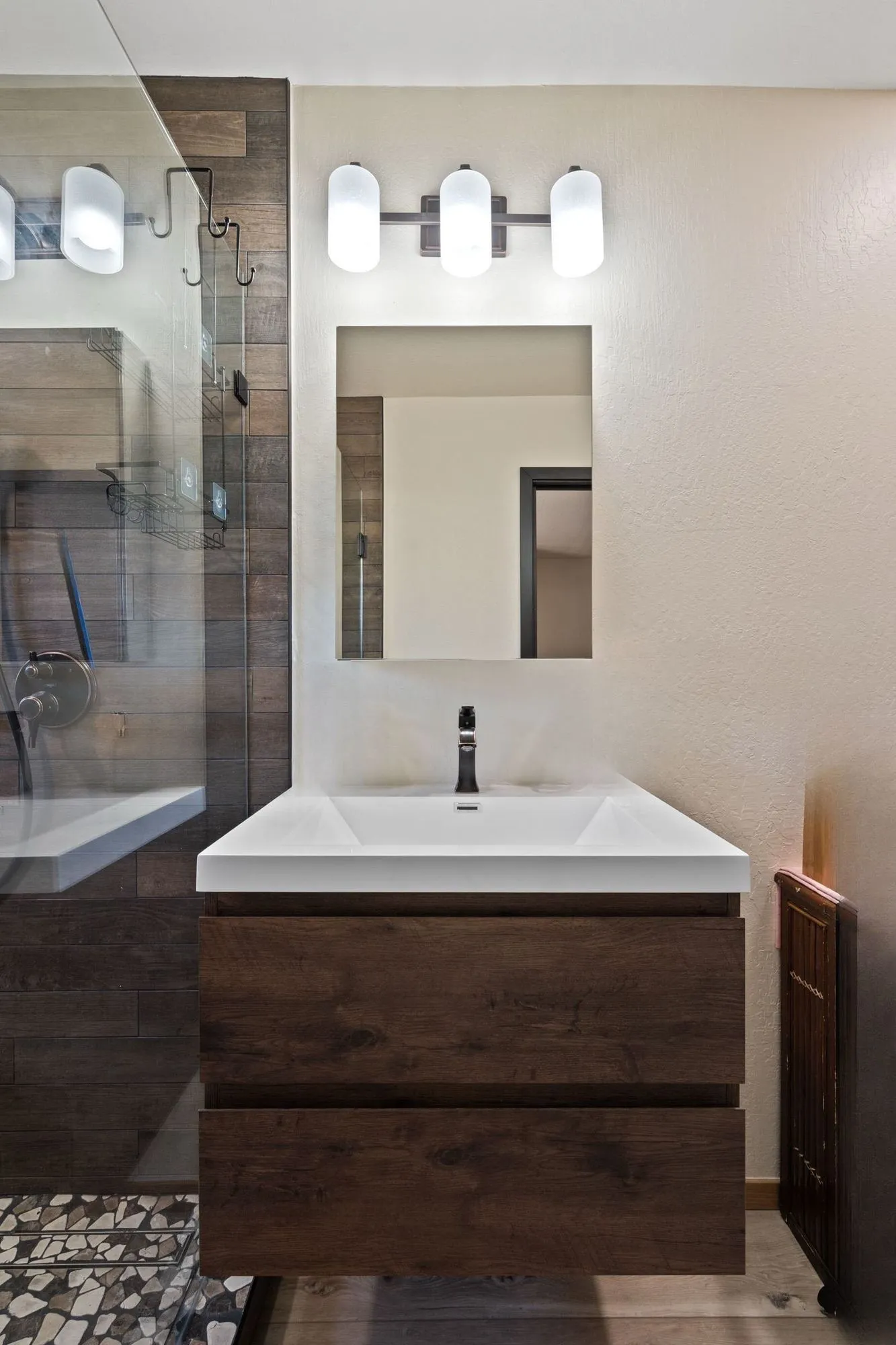 Wall-mounted floating vanity with integrated sink and mirrored cabinet