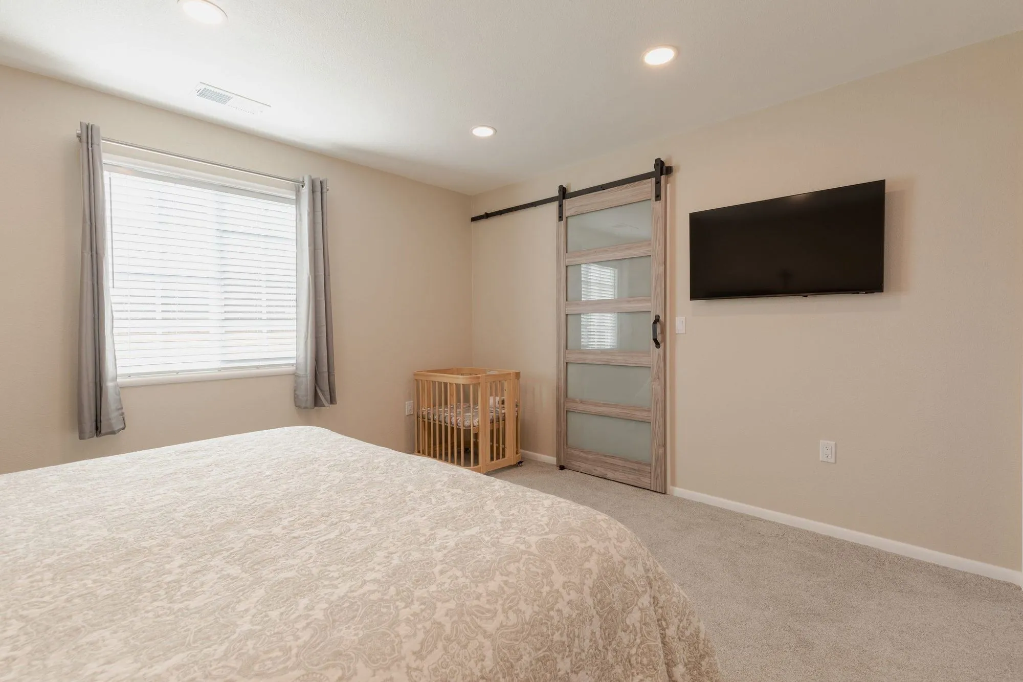 Bedroom with a sliding barn door on a black track