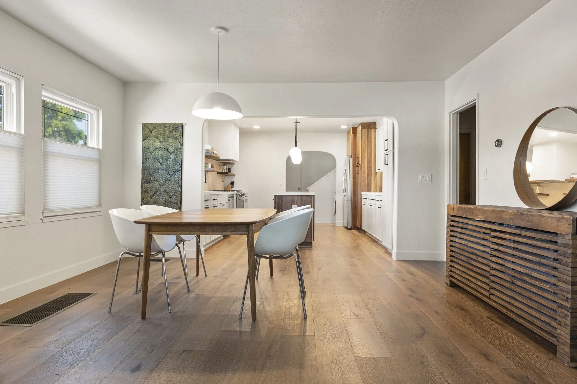 Dining area looking through to the kitchen, with a timber slat console along the wall