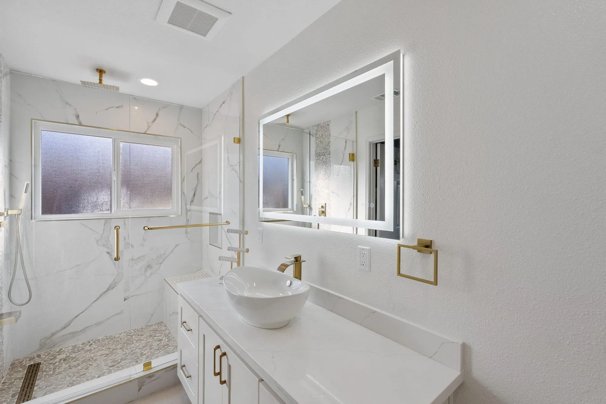 Double vanity with twin backlit mirrors and brushed brass tapware