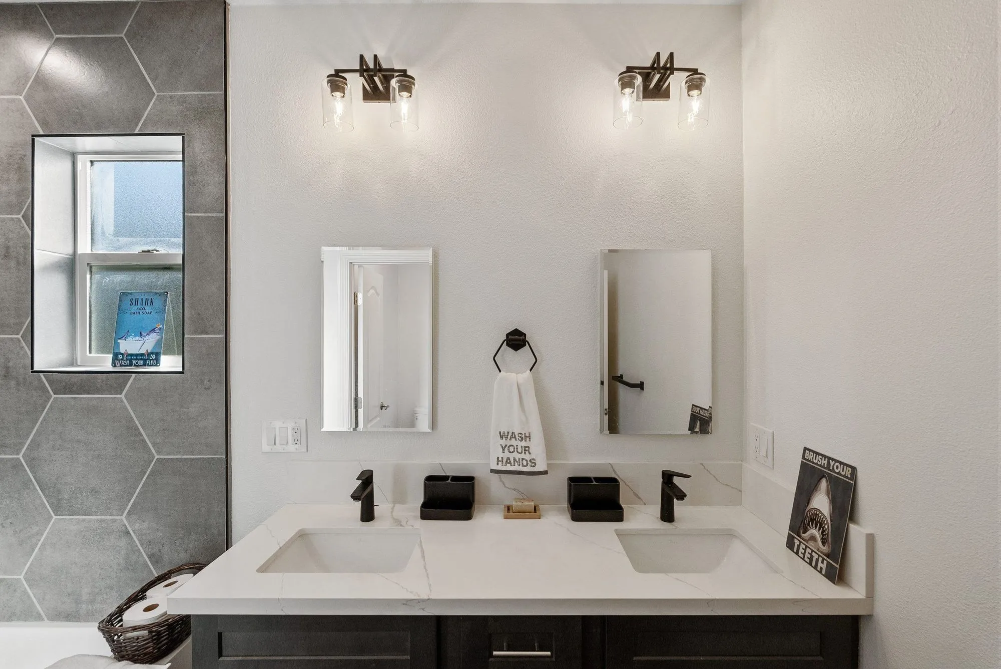 Double vanity in dark cabinetry with twin mirrors and matte-black tapware