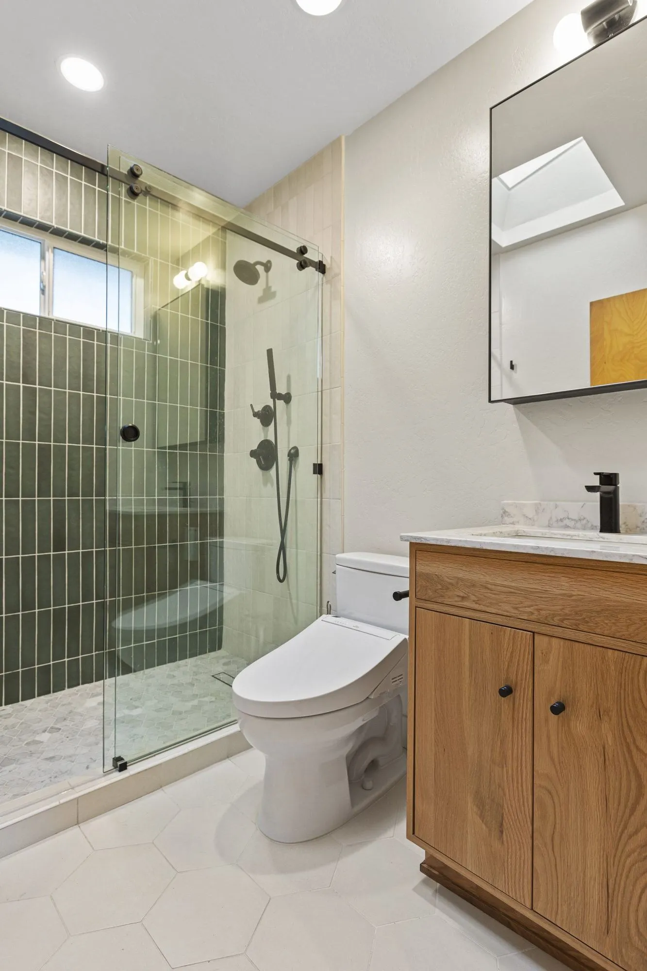 Bathroom in sage-green stacked tile with a timber vanity and black tapware