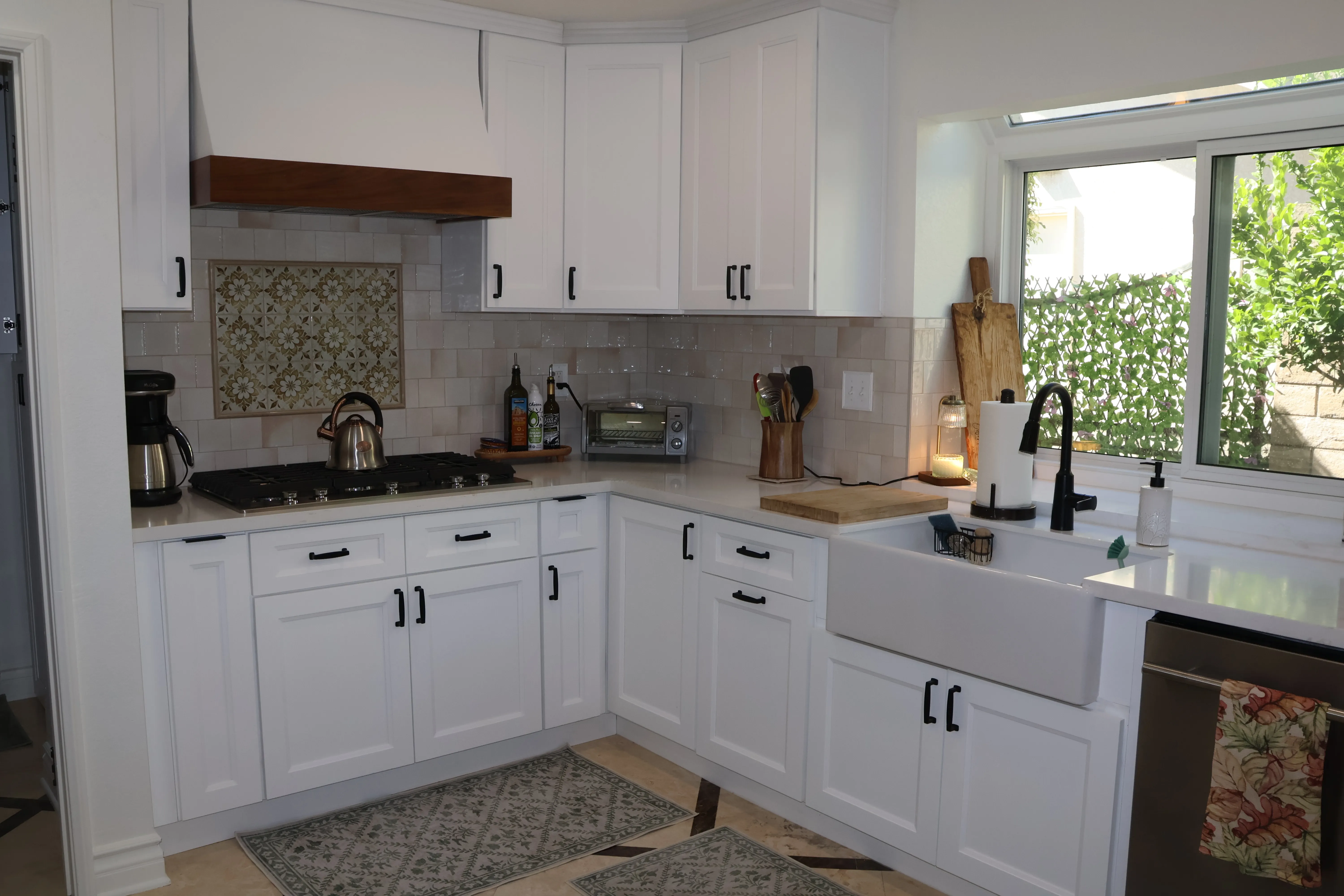 Full L-shape kitchen — wood hood, encaustic tile, apron sink, subway tile, patterned floor