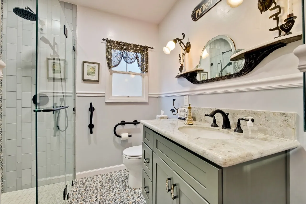 Bathroom after remodel, sage shaker vanity with stone counter and patterned floor tile