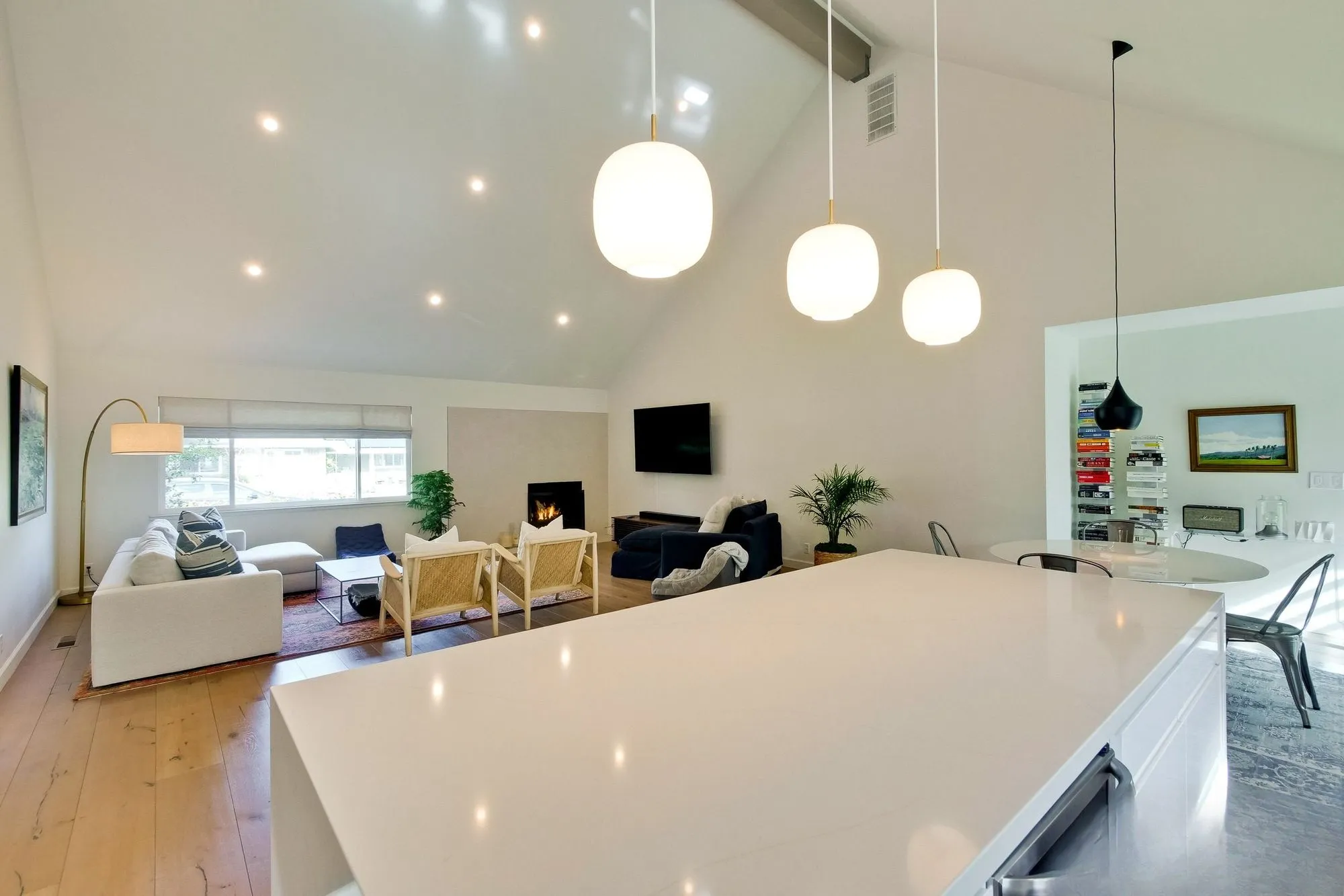 Kitchen after whole-home remodel, white cabinetry under a vaulted ceiling with a large island