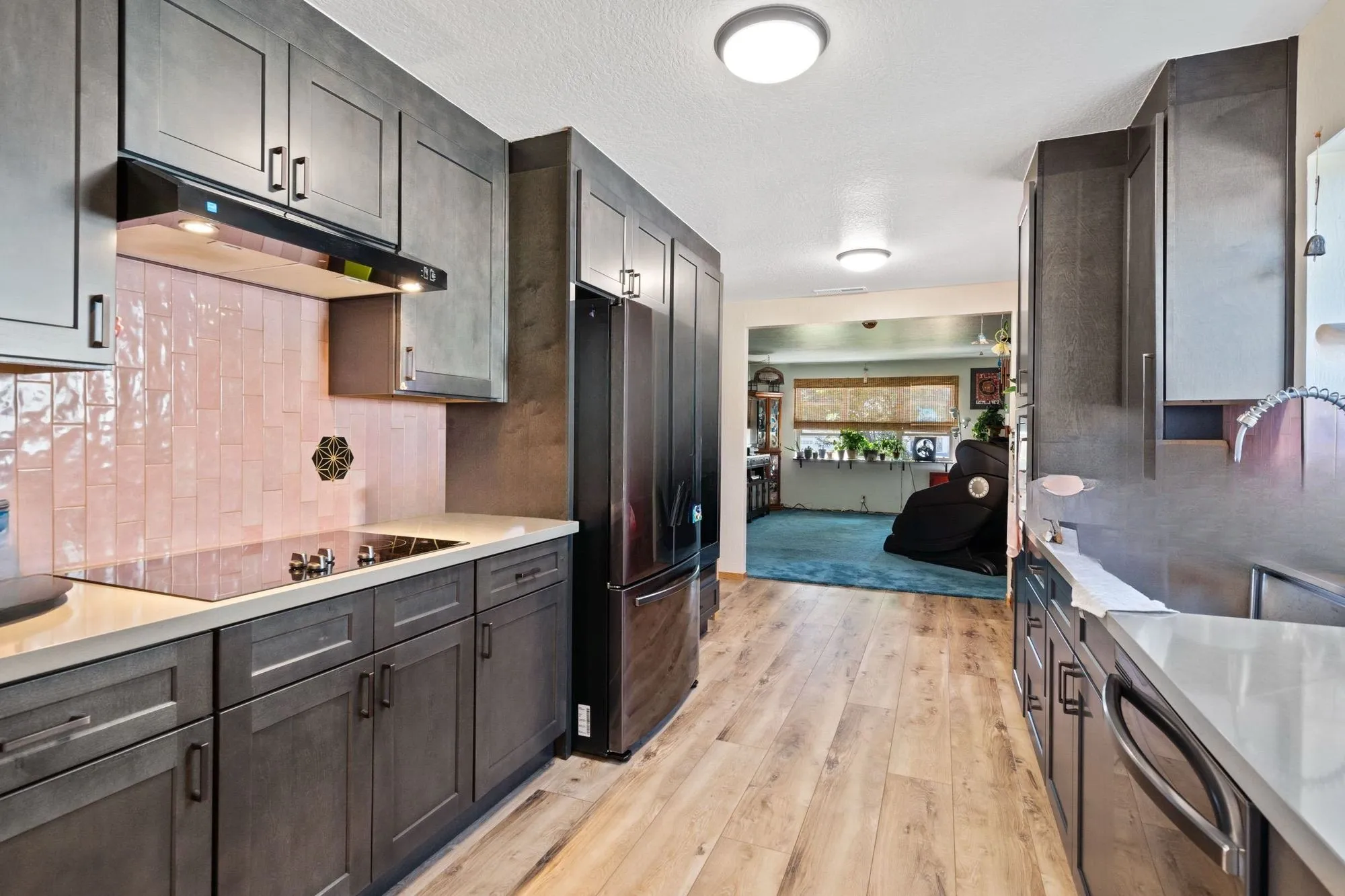 Kitchen range wall with blush tile backsplash and under-cabinet lighting