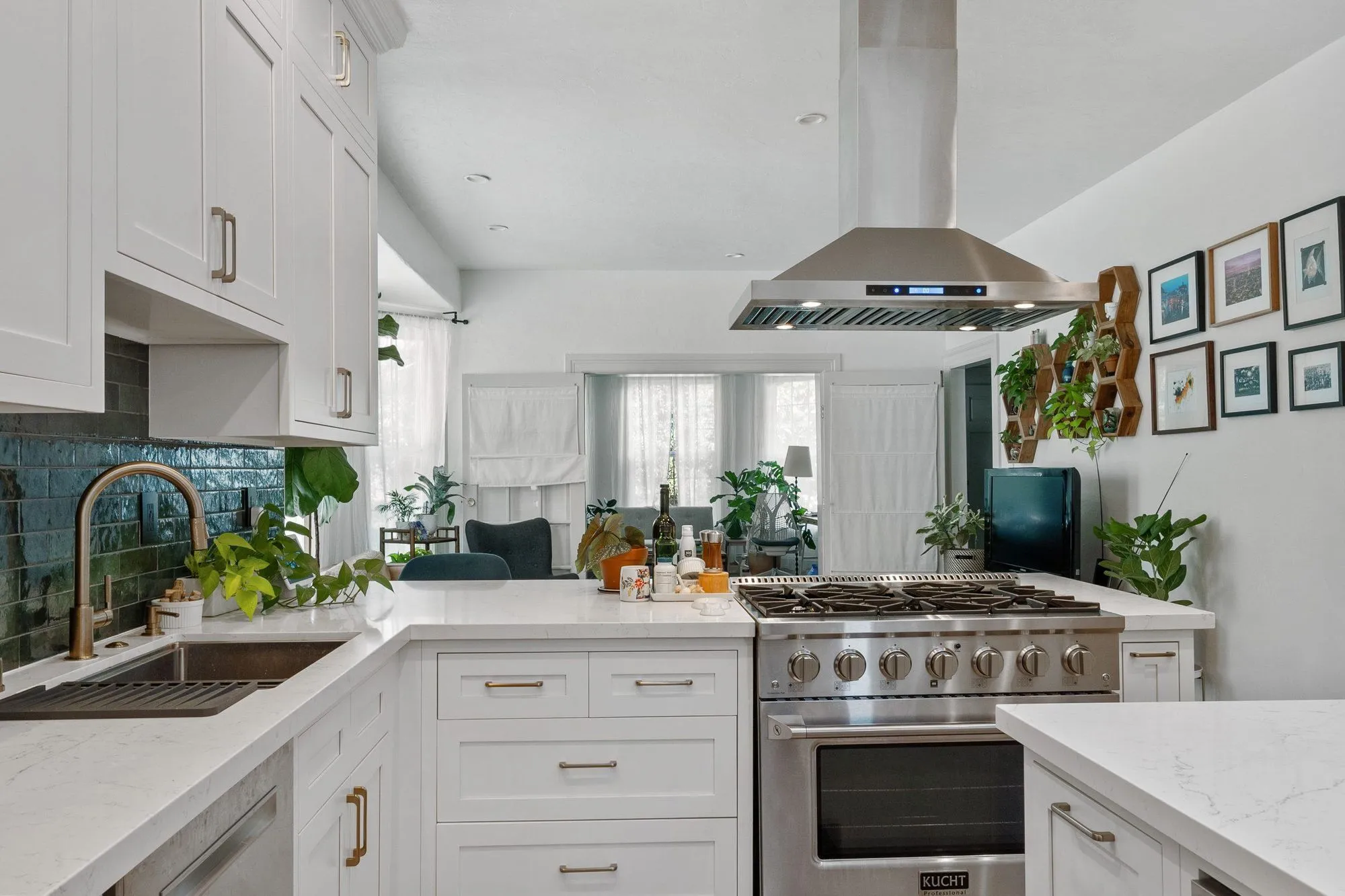 Corner of the kitchen where the teal tile turns, with the range and sink runs meeting