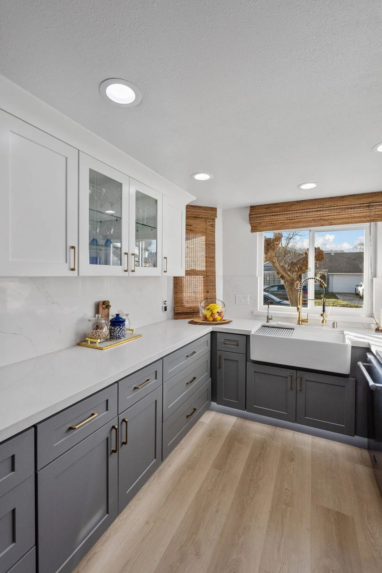 Charcoal lower cabinets below white uppers with glass-fronted doors