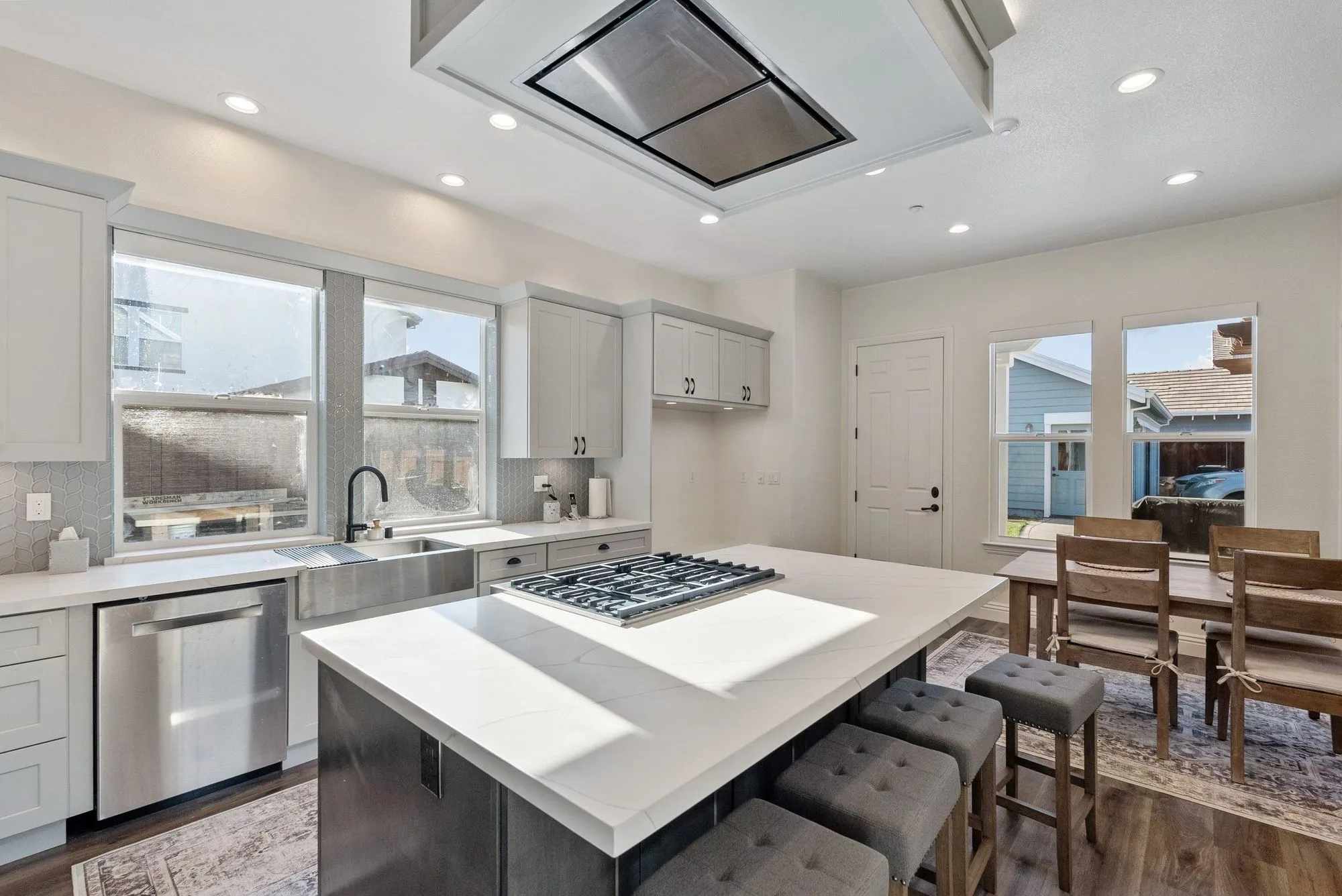 Kitchen island with an inset cooktop, open to the dining area beyond