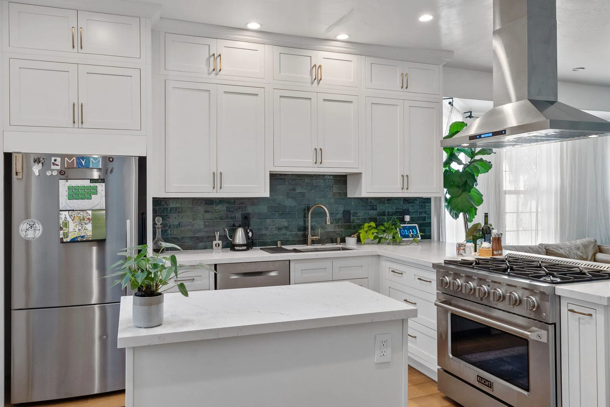 Stainless refrigerator beside the counter run, with the island in the foreground