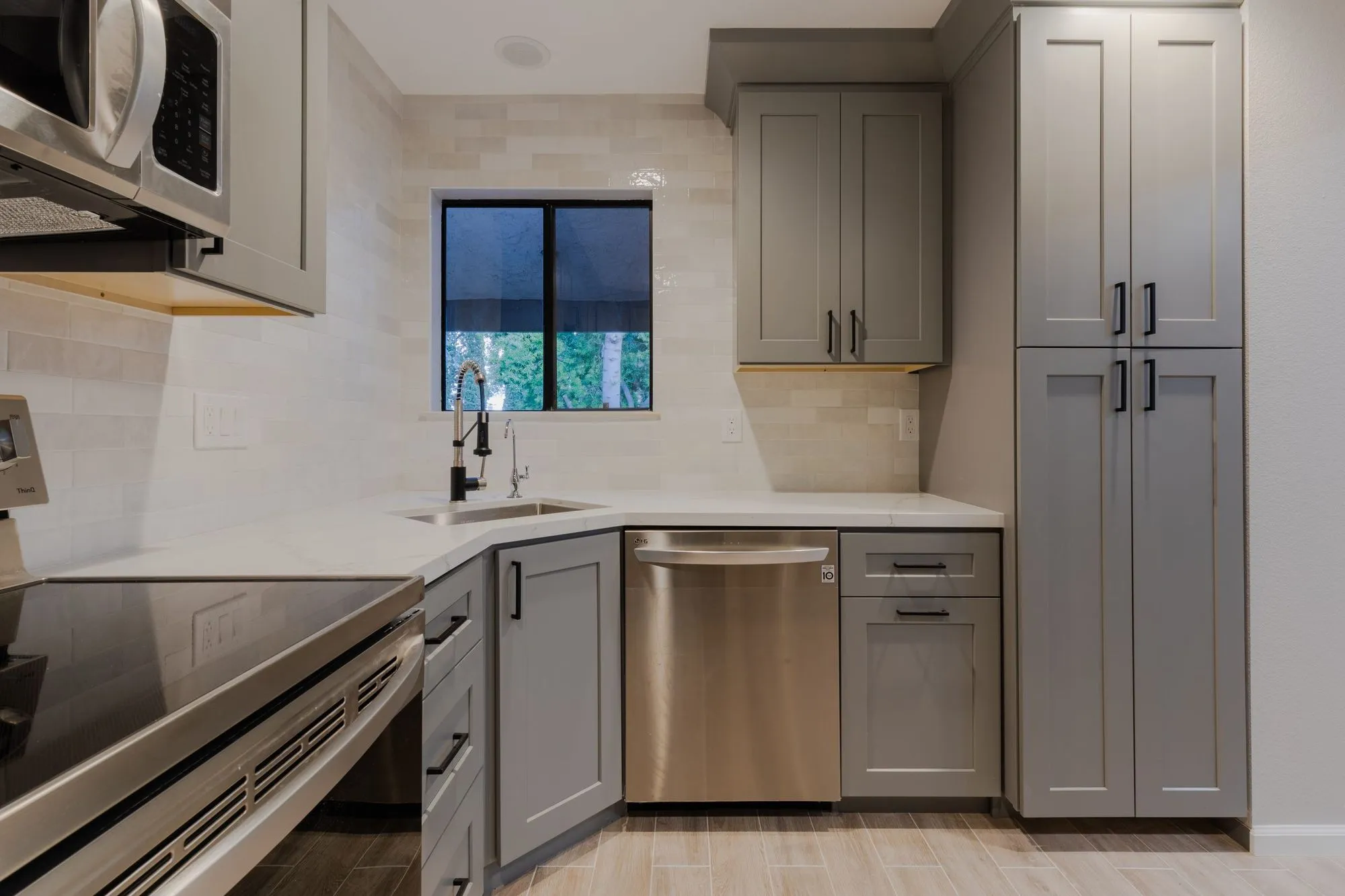 Tall cabinet run with a built-in microwave beside the window