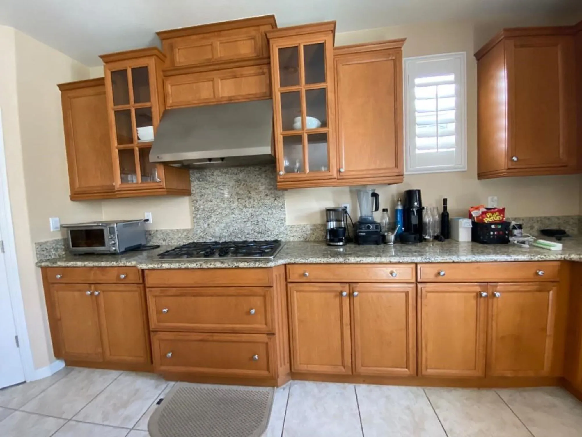 Original kitchen before remodel, honey-oak raised-panel cabinets and granite counters