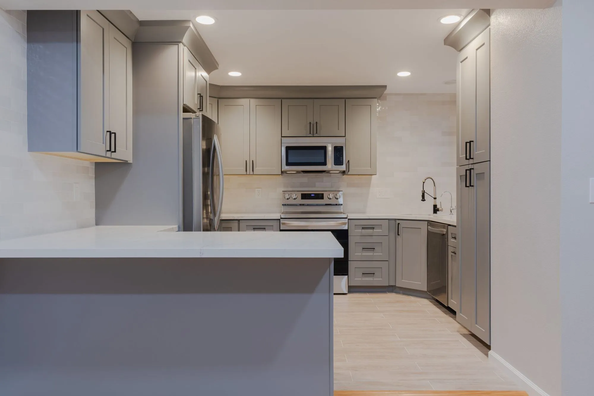 Kitchen peninsula in quartz opening to the adjoining room