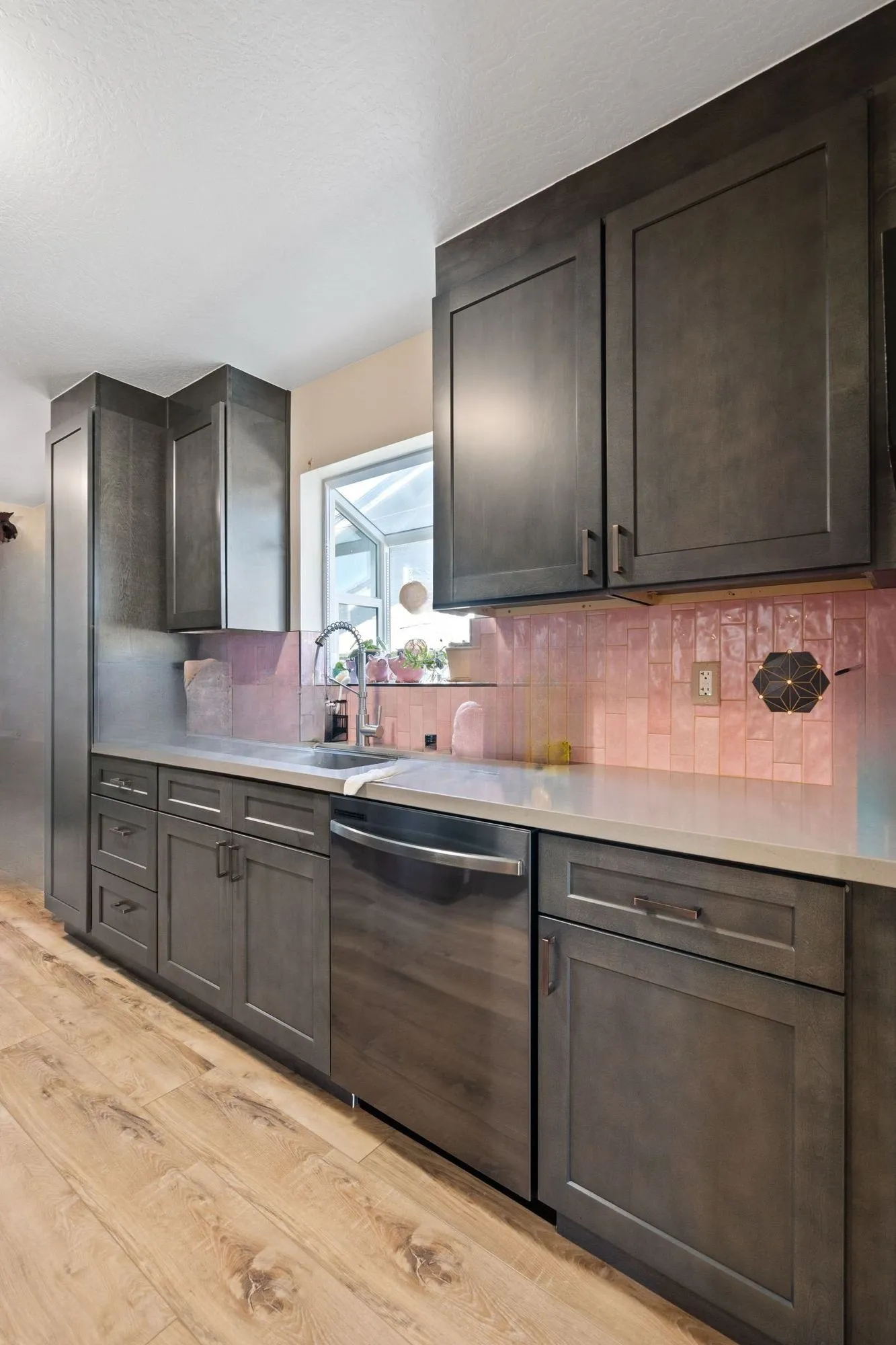 Kitchen counter run with light quartz surface beside a window