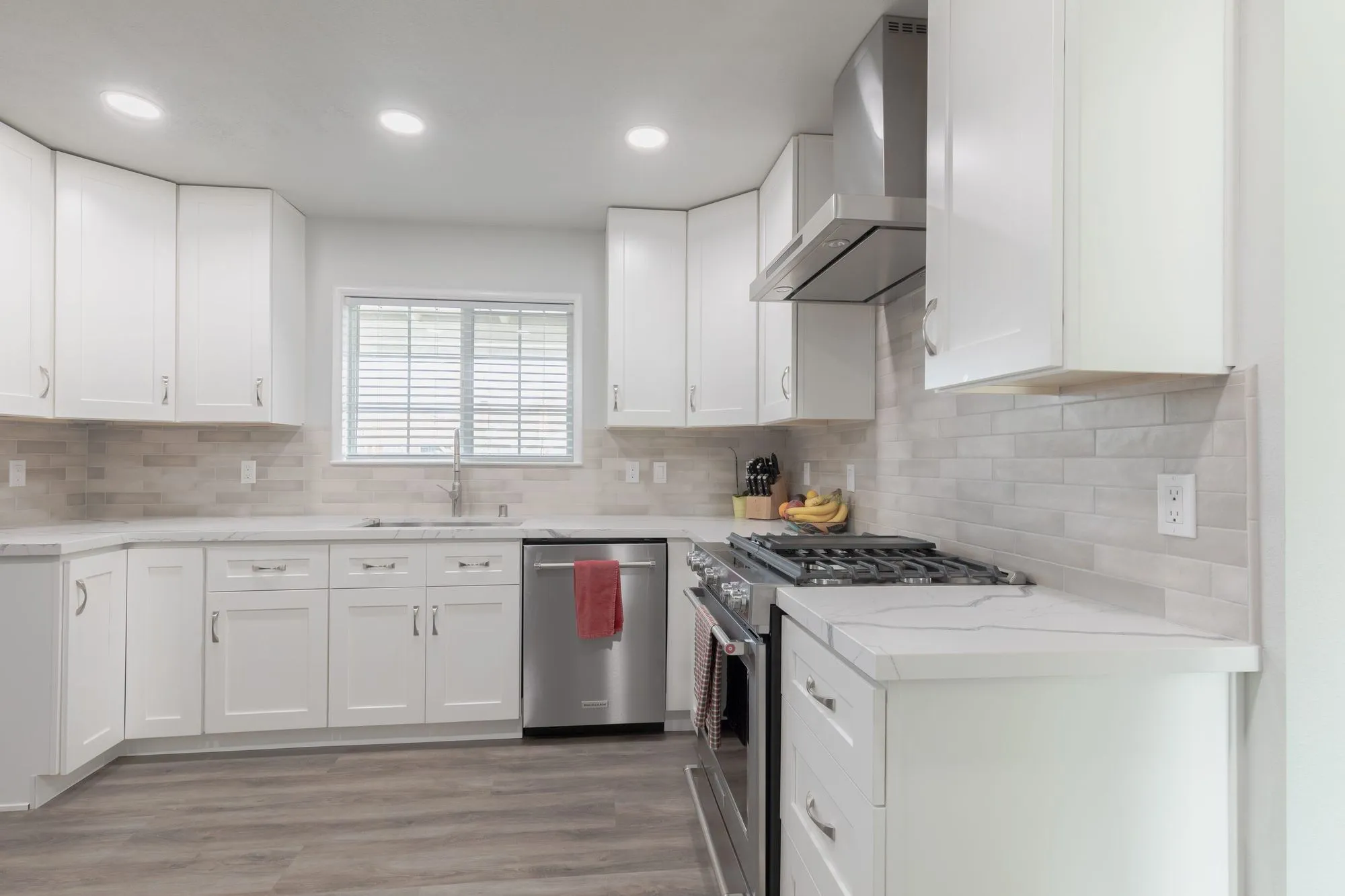 Range and veined quartz counter against the stacked stone-look tile backsplash
