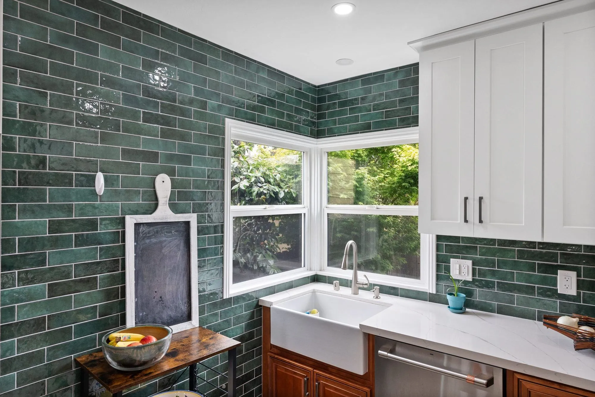 Sink run below a corner window, white quartz counter over timber lower cabinets