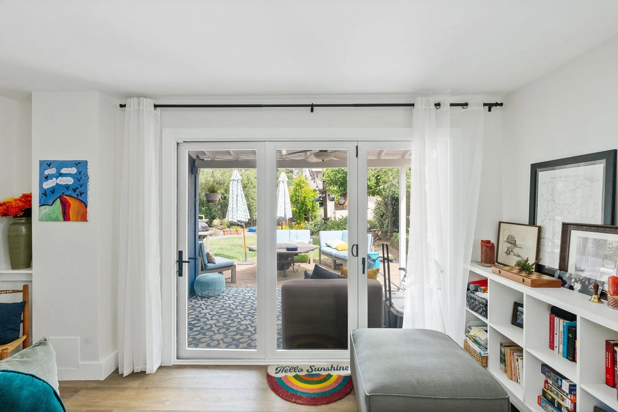 Living room with white built-in shelving beside glazed doors to the patio