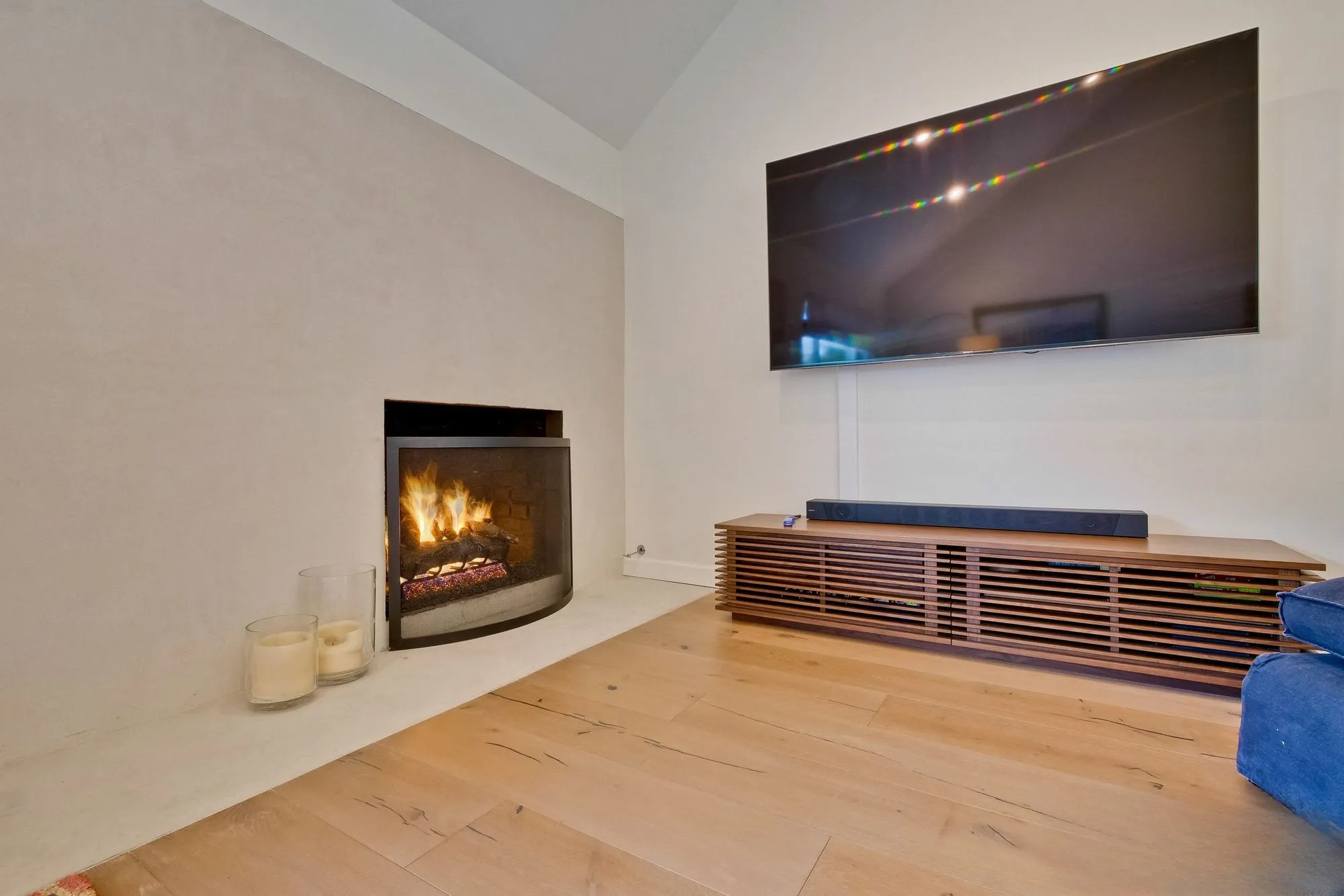 Living room fireplace set into the wall below a mounted screen