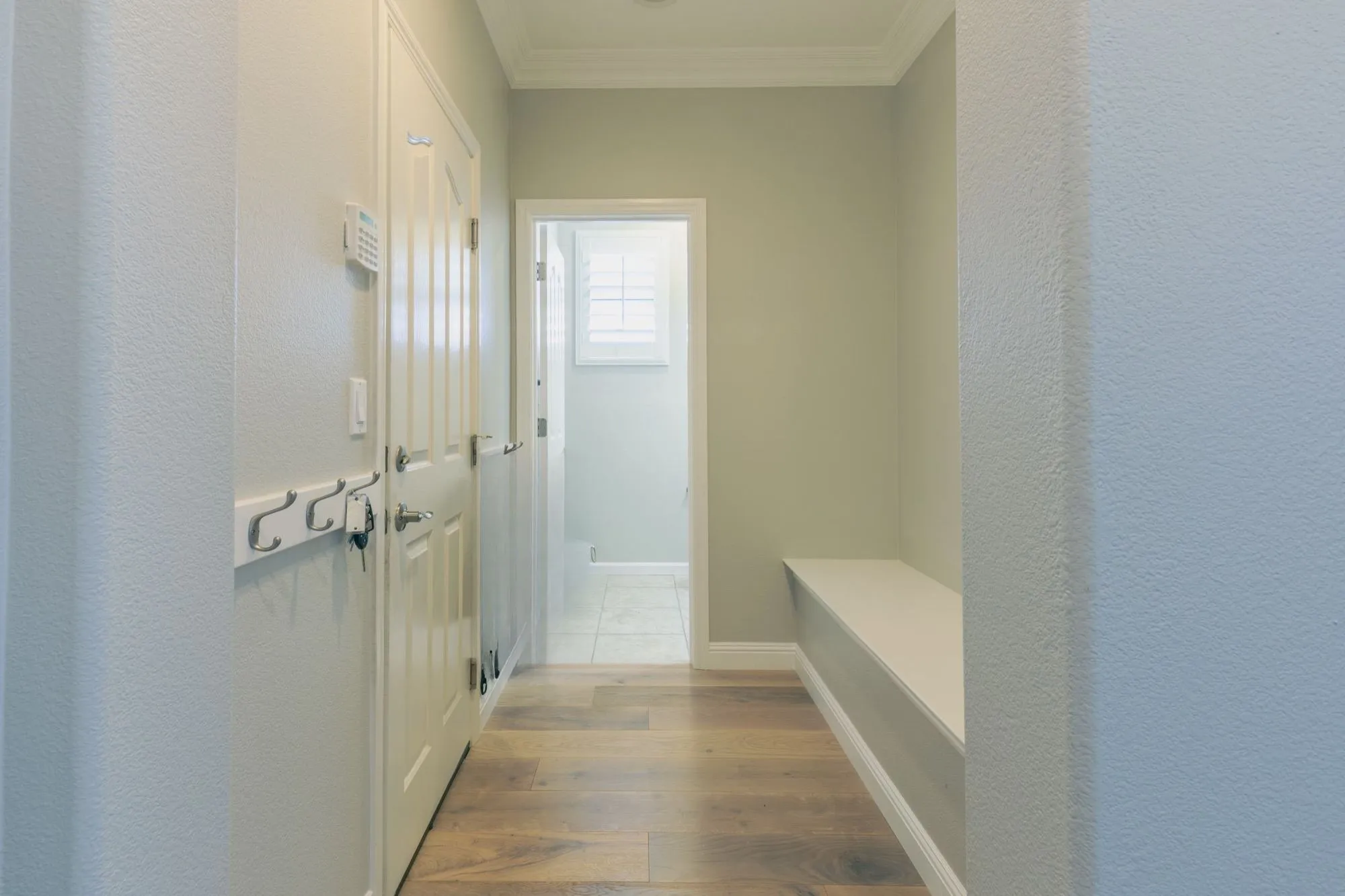 Mudroom with built-in bench and wall hooks off the kitchen