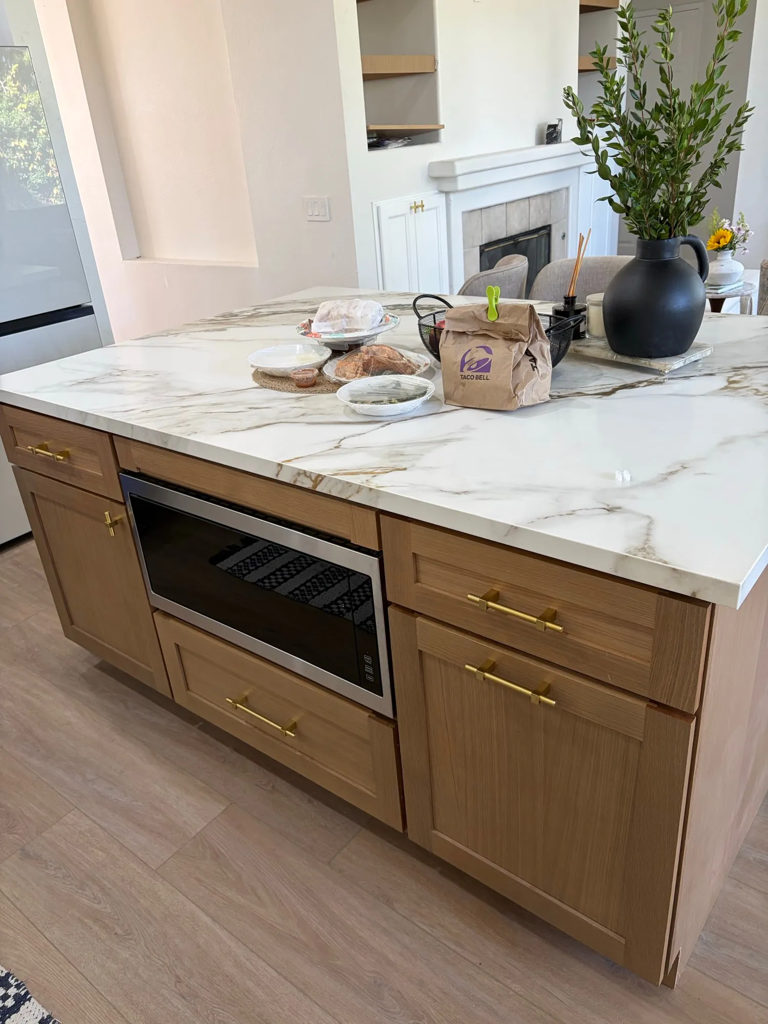 White-oak island with a marble-look top and seating side