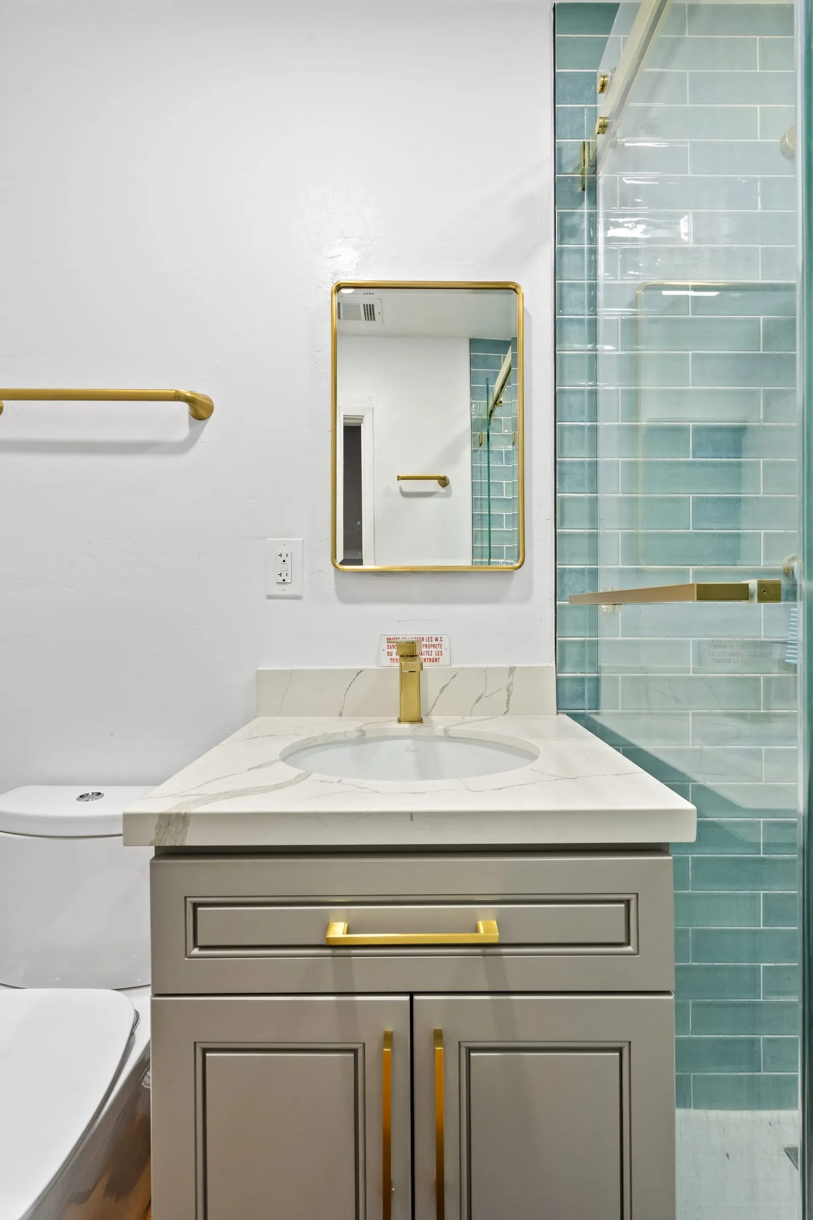 Veined quartz counter with a square brass tap