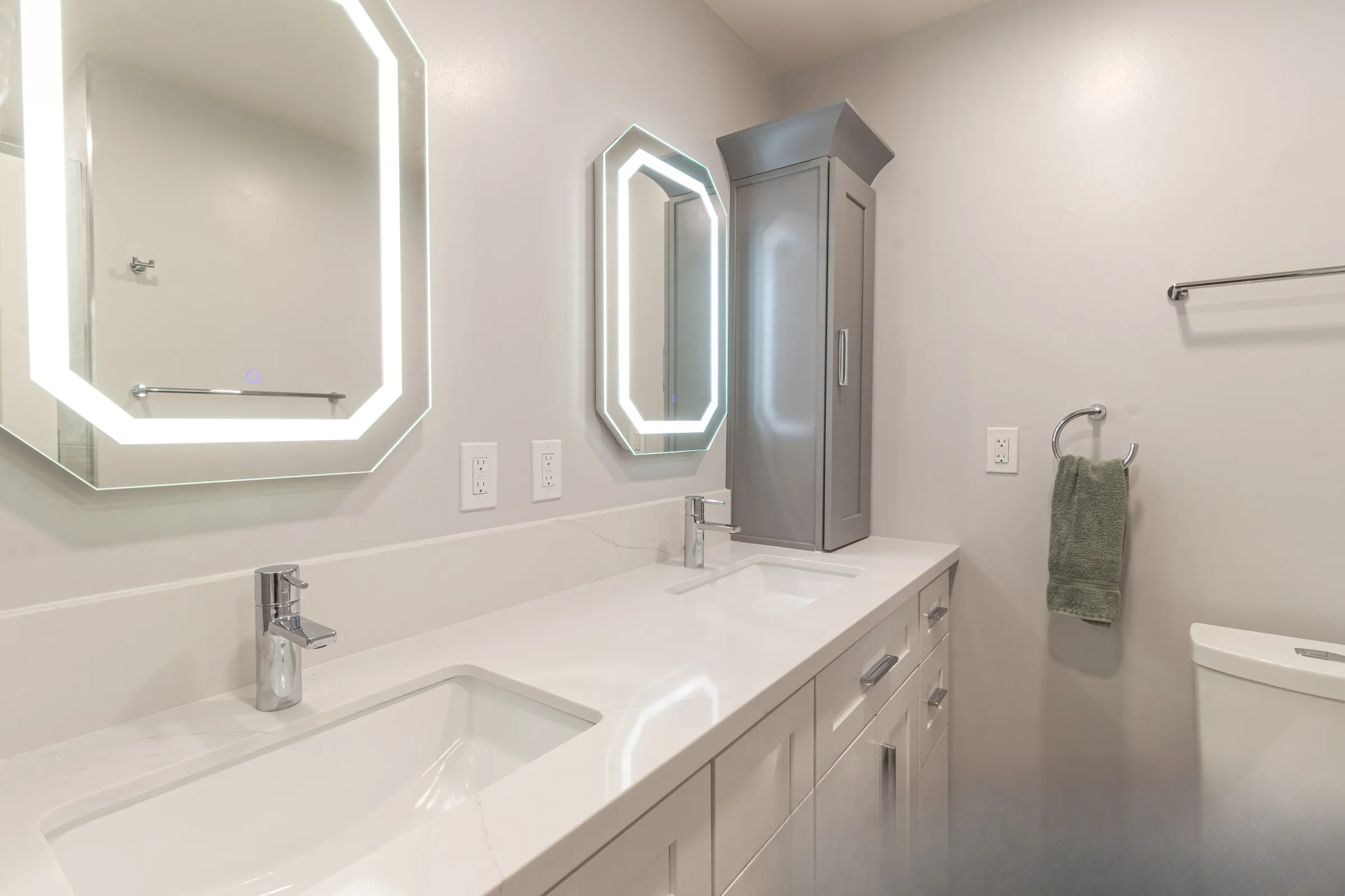 Veined quartz counter with two undermount basins and single-lever chrome mixers