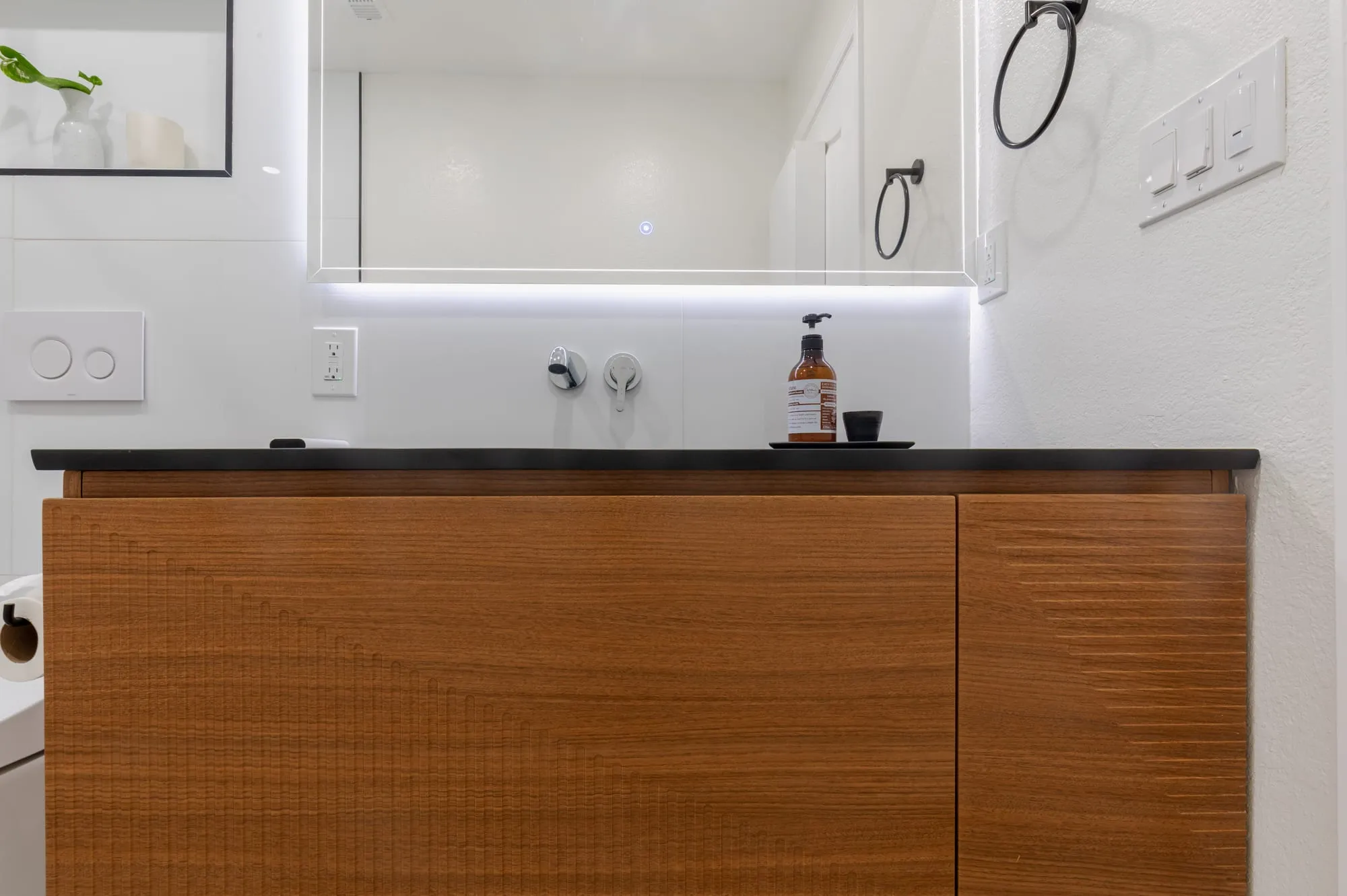 Ribbed wood vanity with a dark counter in the second bathroom