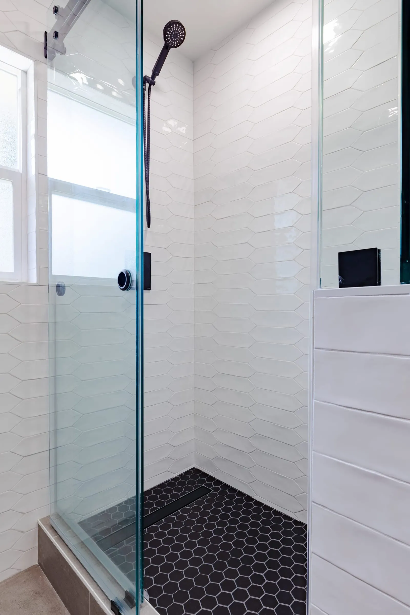Recessed niche in the shower wall behind glass