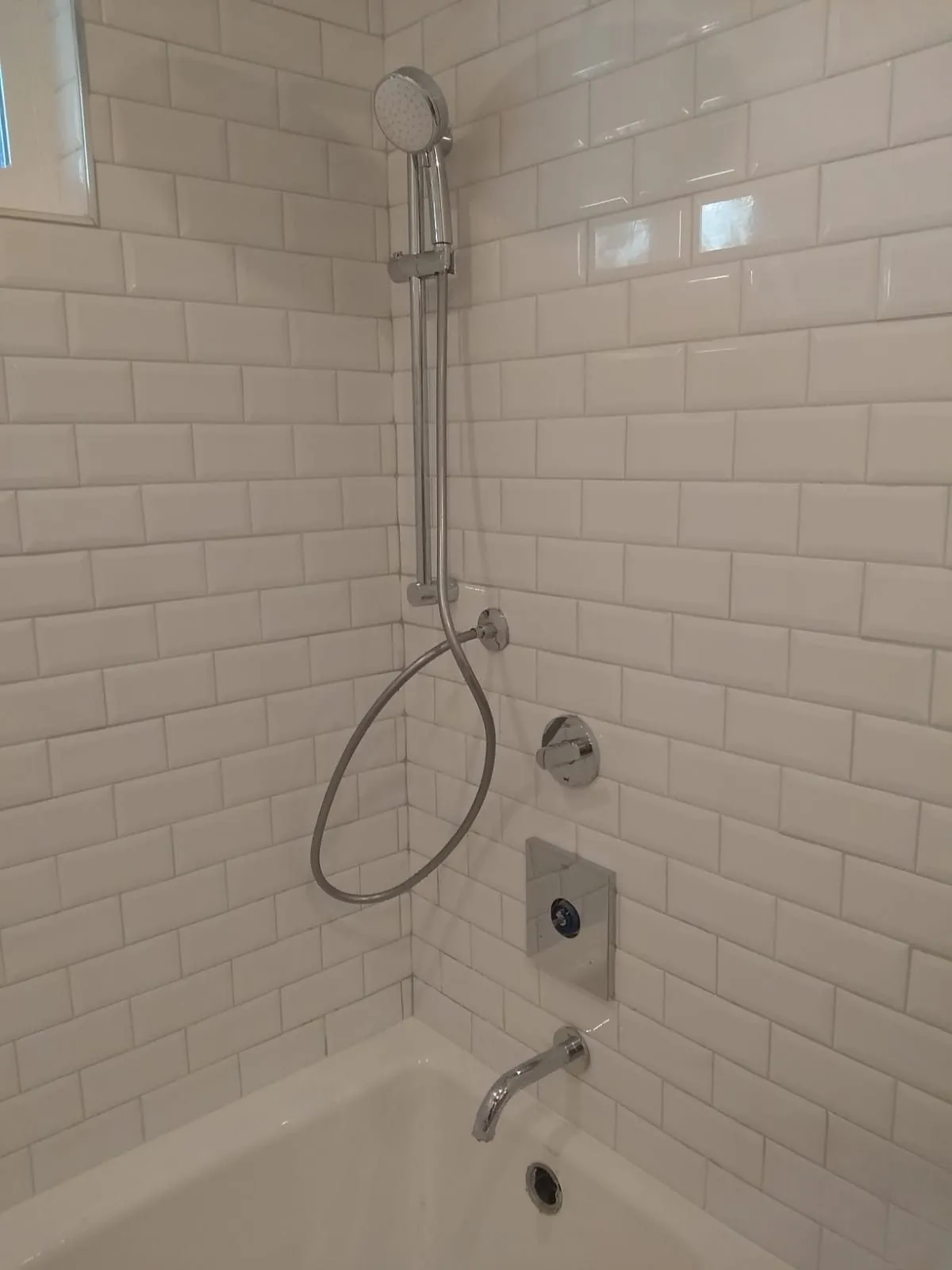 Shower wall during the build, tiled with the mixer and rail fitted