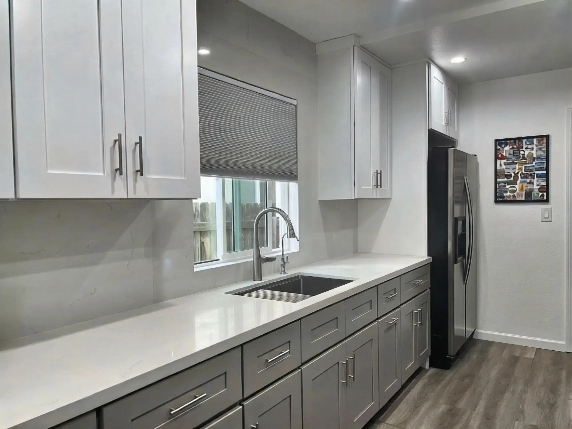 Sink run under the window, grey shaker drawers below white uppers