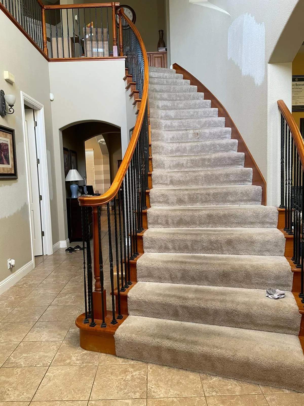 Original staircase before remodel, carpeted treads with a stained timber handrail