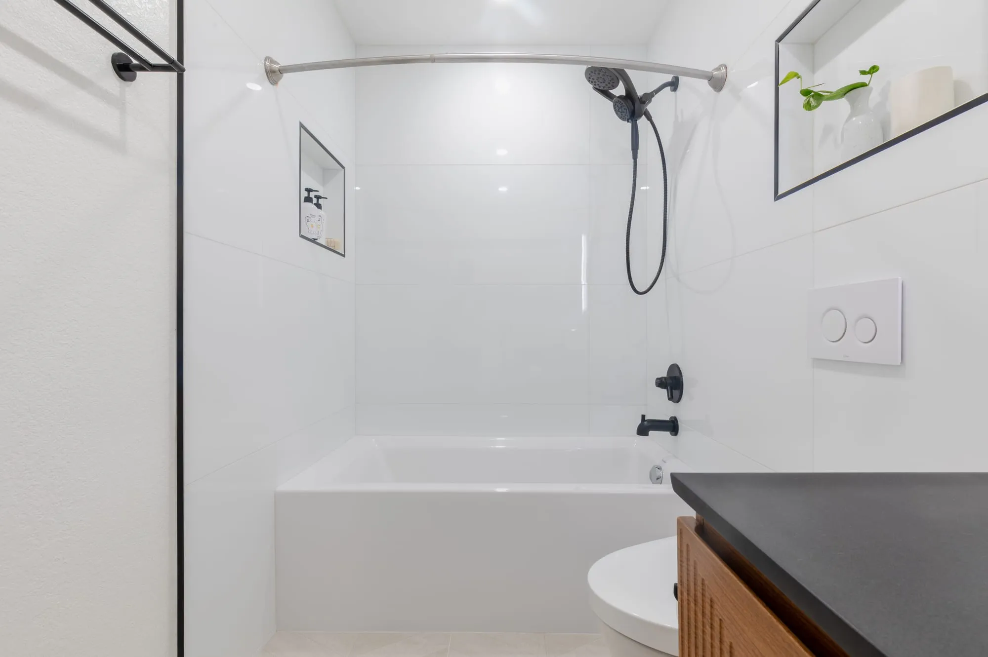 Alcove tub with a hand shower on the wall