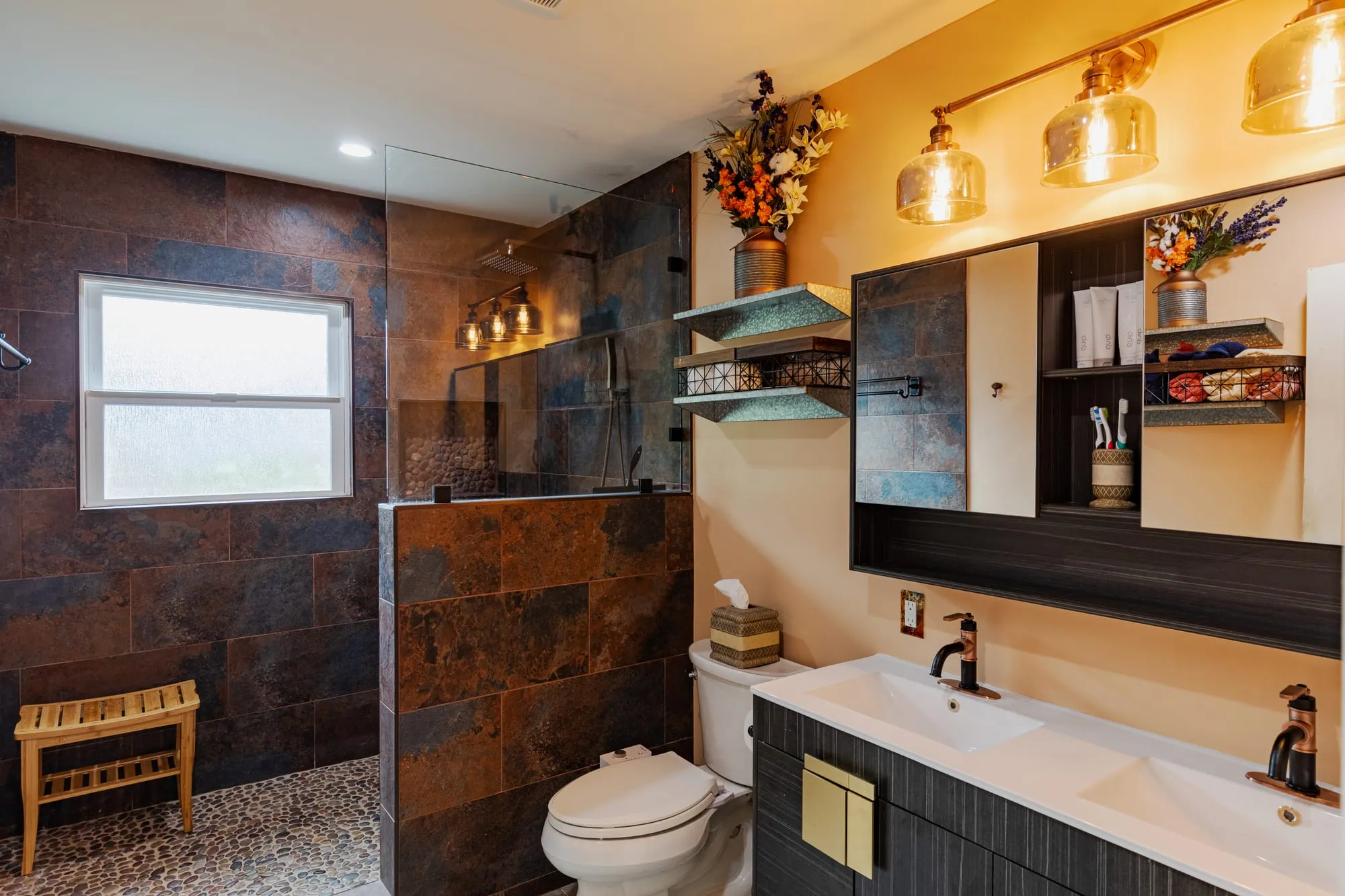Vanity mirror between warm wall sconces above the ribbed vanity