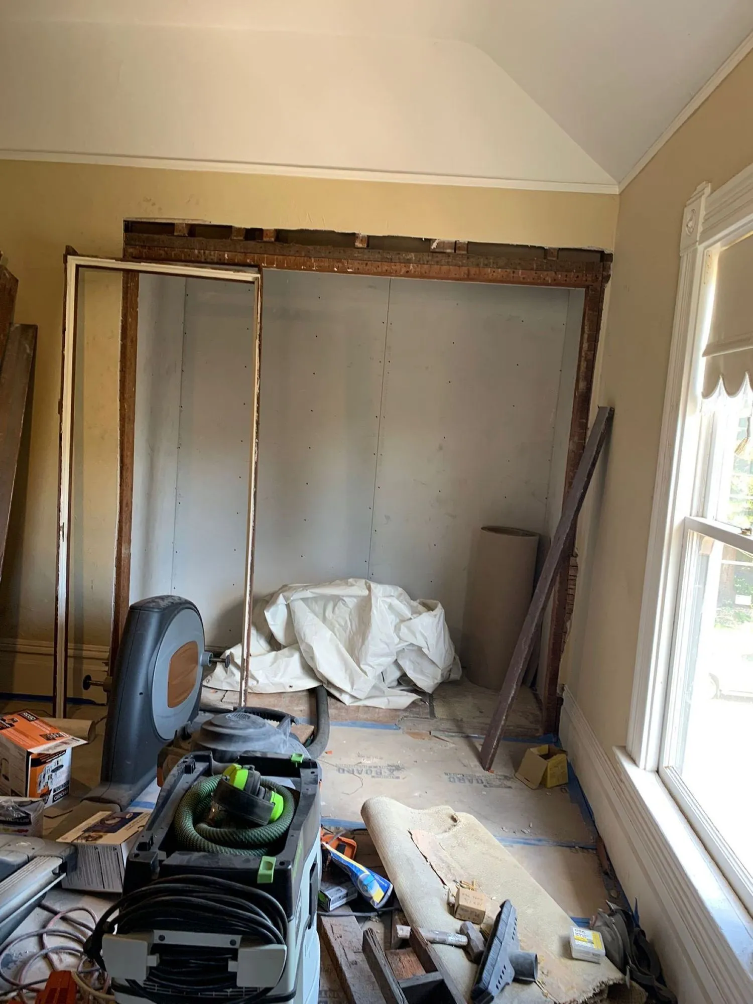 Wall opening framed out during demolition, drywall removed to studs